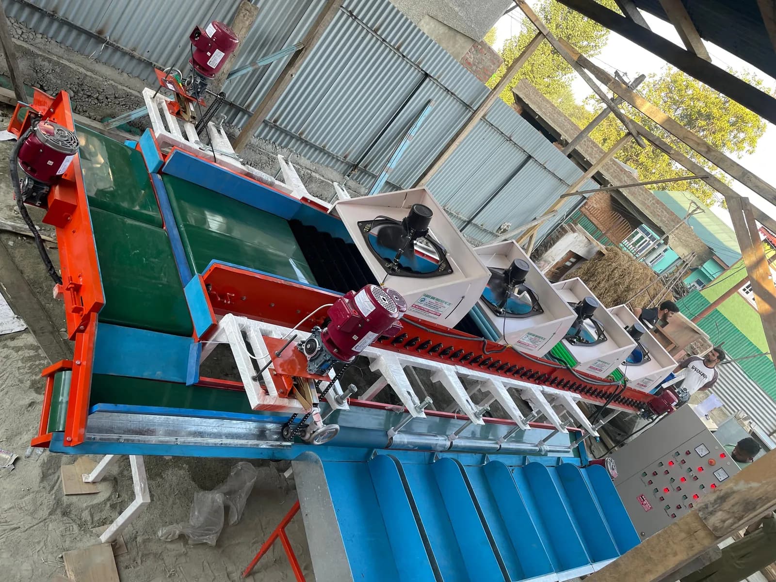 Apple grading machine with a green belt and blue sizing channels being set up